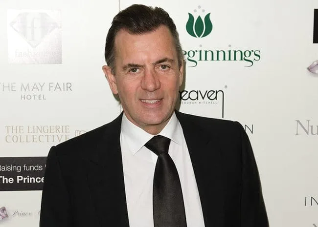 Duncan Bannatyne OBE in a dark suit at a charity gala, photographed against the event's sponsor backdrop